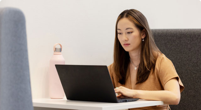Femme asiatique travaillant sur un ordinateur portable à un bureau